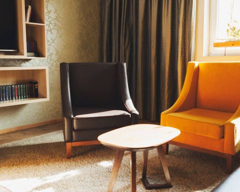 A view of the Herrenzimmer as a conference room with three heavy leather armchairs, a leather couch, designer lamps and an oversized screen for presentations or TV.