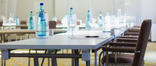 Ground-floor meeting room with natural light and a U-shaped table arrangement -  meeting beverages provided in large water bottles