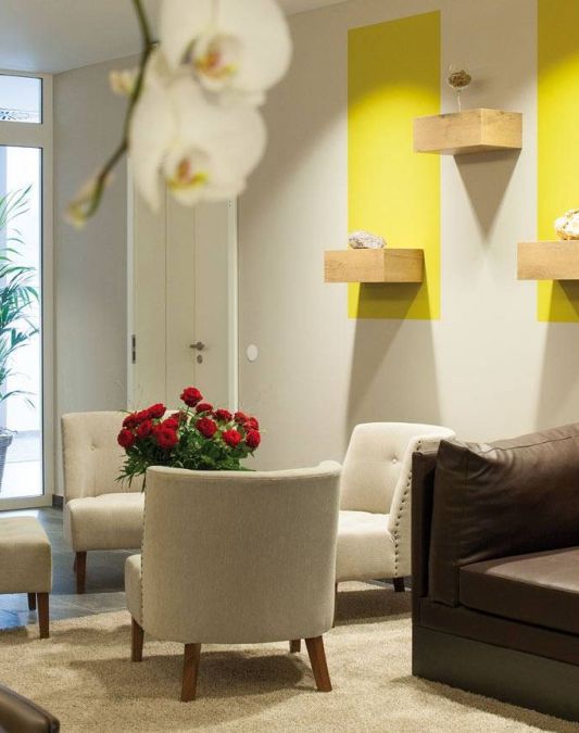 Lobby im Weinhotel Kaisergarten mit Designermobiliar 3 Stuehle ein grosses Sofa im Hintergrund links die Tuere des Hoteleingangs