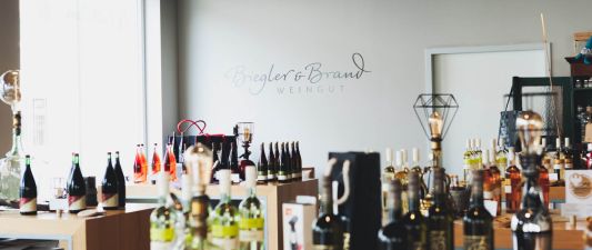 A view inside the wine shop or wine bar at the Weinhotel Kaisergarten, featuring numerous bottles of wine attractively displayed here