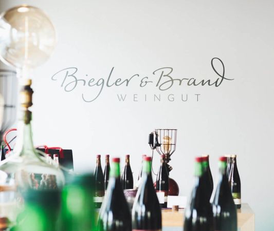 Wine shop and wine bar at the Weinhotel Kaisergarten in Alzey, with bottles of wine displayed in the foreground and the Biegler 