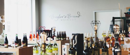 A view inside the wine shop or wine bar at the Weinhotel Kaisergarten, featuring numerous bottles of wine attractively displayed here