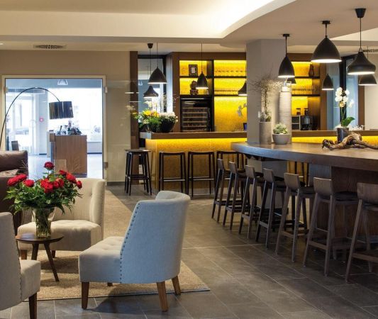 Lobby in the Weinhotel Kaisergarten with designer furniture 3 chairs a large sofa in the background on the left the door to the wine shop and on the right the counter of the wine bar