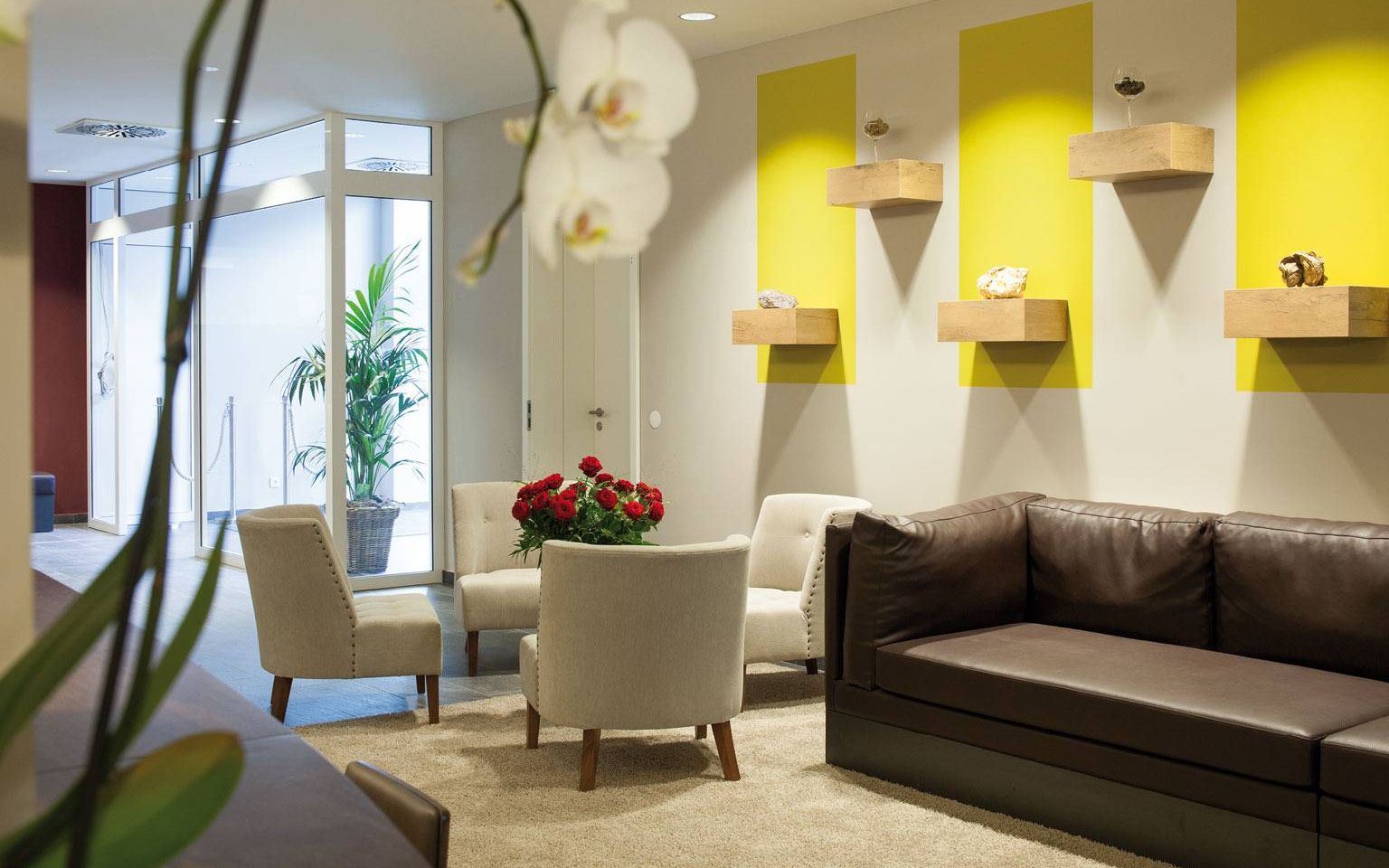 Lobby in the wine hotel Kaisergarten with designer furniture 3 chairs a large sofa in the background left the door of the hotel entrance