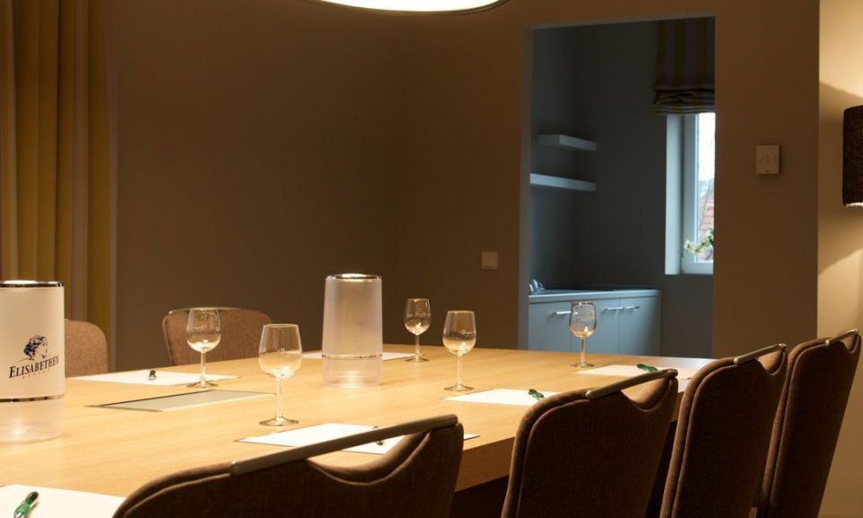 Classic conference room Block seating with 8 chairs, large TV on the wall Designer lights above the table