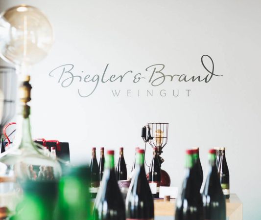Wine shop and wine bar at the Weinhotel Kaisergarten in Alzey, with bottles of wine displayed in the foreground and the Biegler 