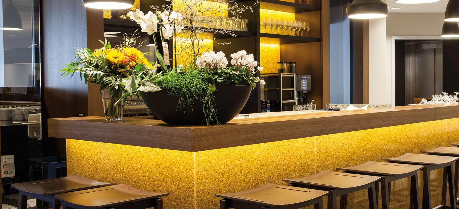 View of bar counter with bar stools and the bar with the back walls in the background