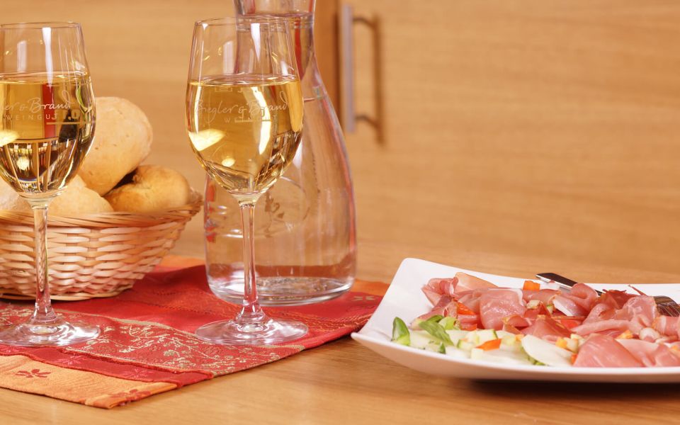 Snack at the Weinhotel Kaisergarten Alzey various types of bread in a basket mixed sausage and ham platter carafe of water and two glasses filled with white wine