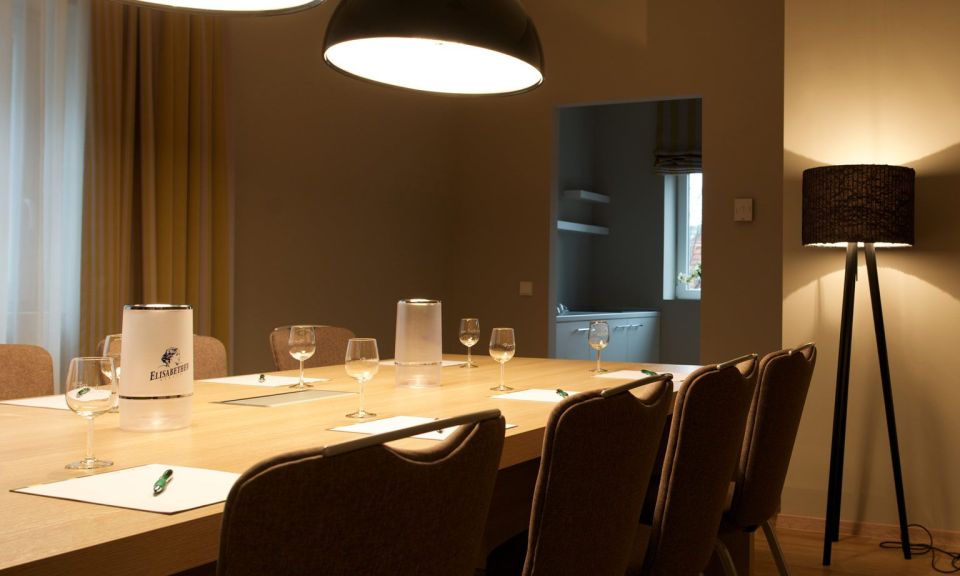 Classic conference room Block seating with 8 chairs, large TV on the wall Designer lights above the table