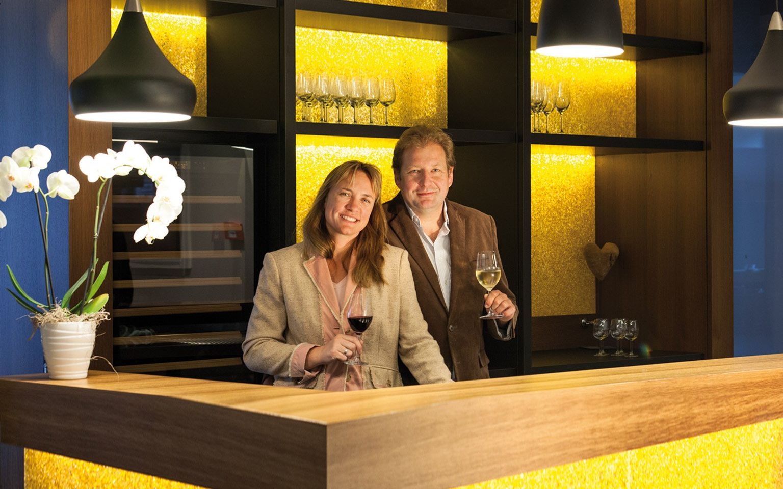 Behind the counter of the hotel bar is the owner couple Petra Brand and Andreas Biegler