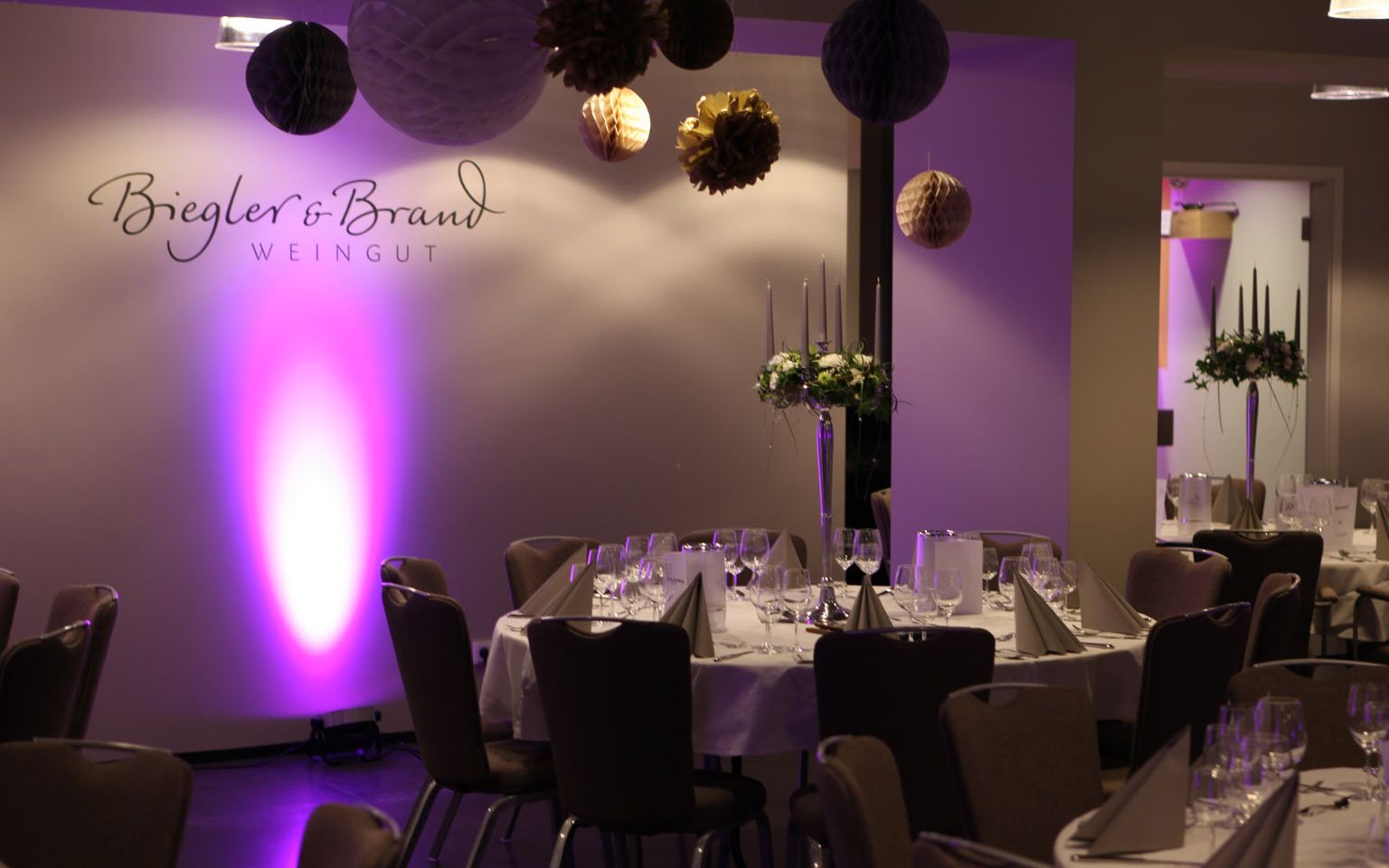 New Year's Eve celebration at the Weinhotel Kaisergarten Alzey with festively decorated tables and chairs and a light organ with violet light