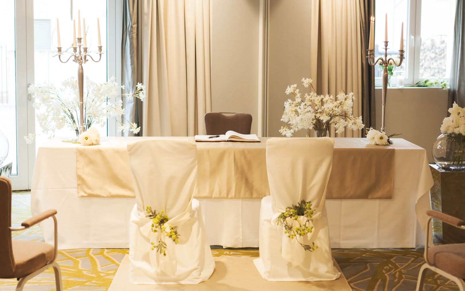 Wedding celebrations at the Weinhotel Kaisergarten in Alzey View of the table for the registrar and the two decorated chairs for the bride and groom