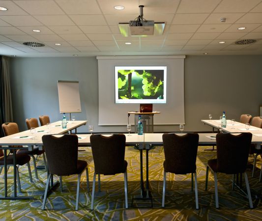 A conference room with seating on the ground floor of the Weinhotel Kaisergarten, featuring a U-shaped table arrangement