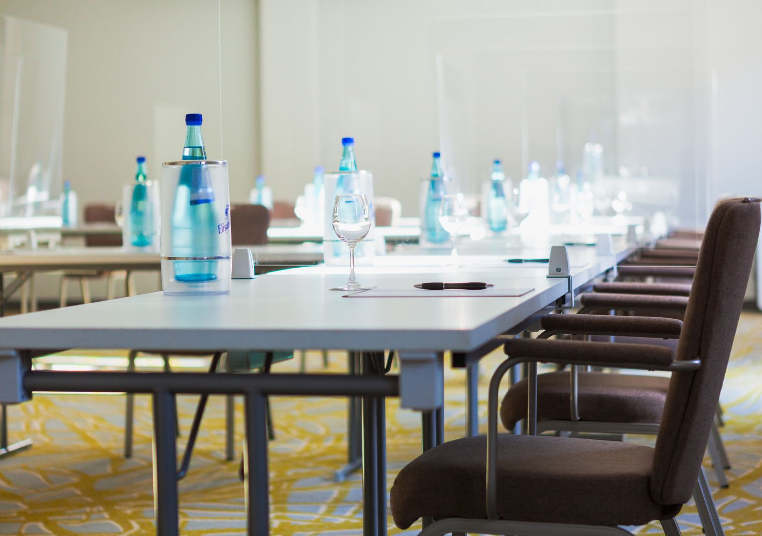 Meeting room on the ground floor Carpeted flooring Daylight U-shaped seating Water bottles, cooler Glasses