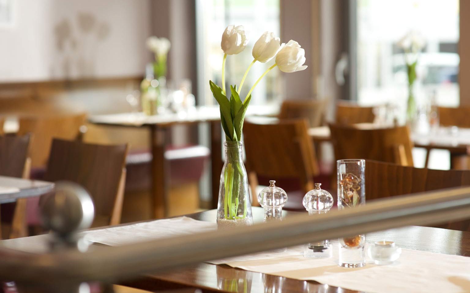 View of tables with floral decorations  in the Weinrestaurant & Vinothek Kaisergarten in Alzey