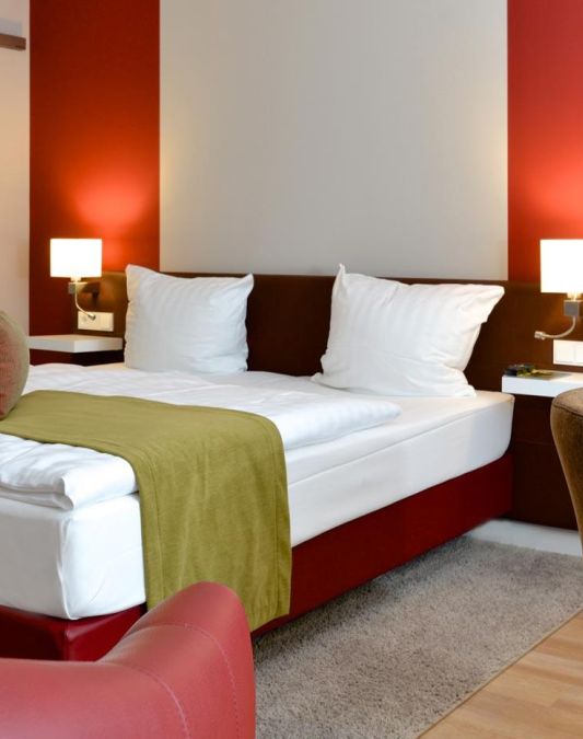 Rooms in the Spaetlese category at the Kaisergarten Alzey wine hotel View of the spacious double bed The colours of wine dominate