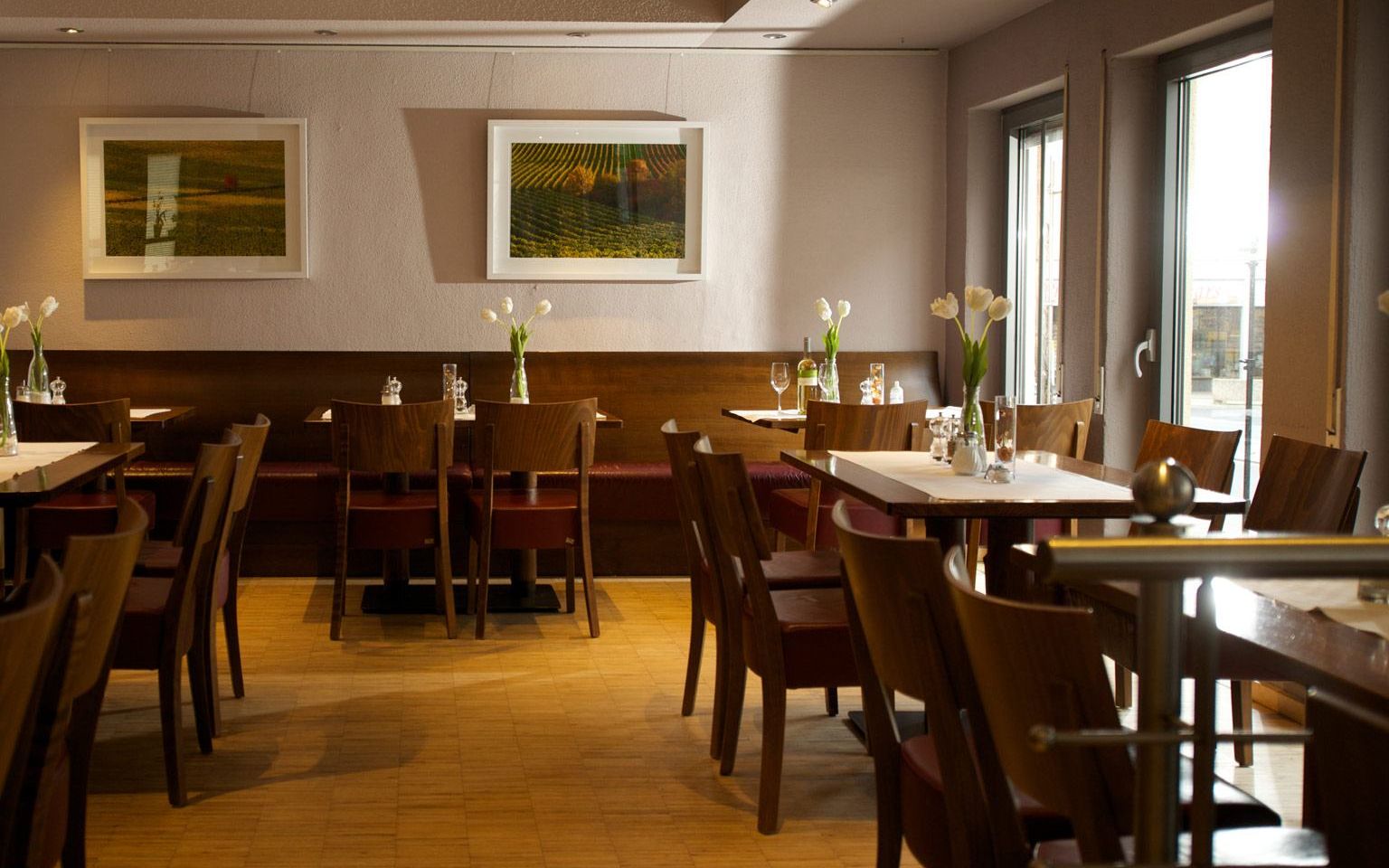 View of set tables on the slightly raised gallery in the Kaisergarten wine restaurant & vinotheque in Alzey