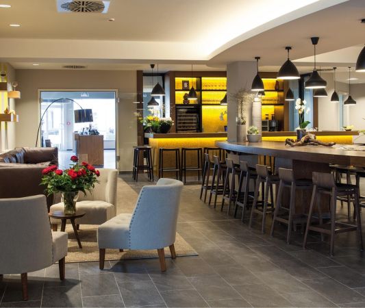 Lobby in the Weinhotel Kaisergarten with designer furniture 3 chairs a large sofa in the background on the left the door to the wine shop and on the right the counter of the wine bar