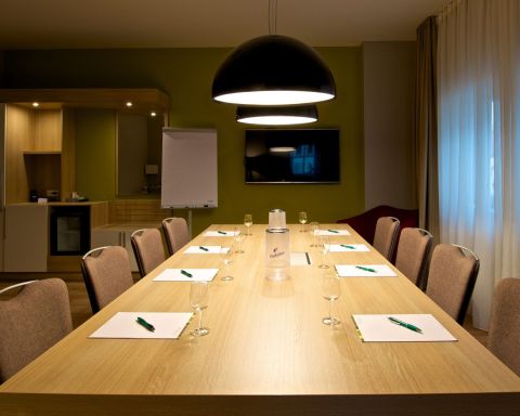 Conference room Classic Block seating with 8 chairs, large TV on the wall Designer lights above the table